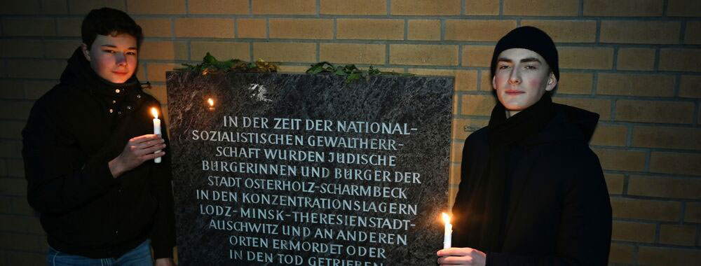 Gustav Grünthal und Jerik Dickerboom (rechts) haben am Osterholzer Denkmal für die Synagoge  Kerzen entzündet, um die Schrecken der Geschichte nicht in Vergessenheit geraten zu lassen. (CARMEN JASPERSEN)